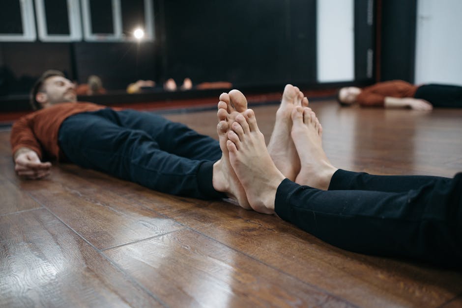 Group of diverse people relaxing in a comfortable seated pose in a sunlit yoga studio.