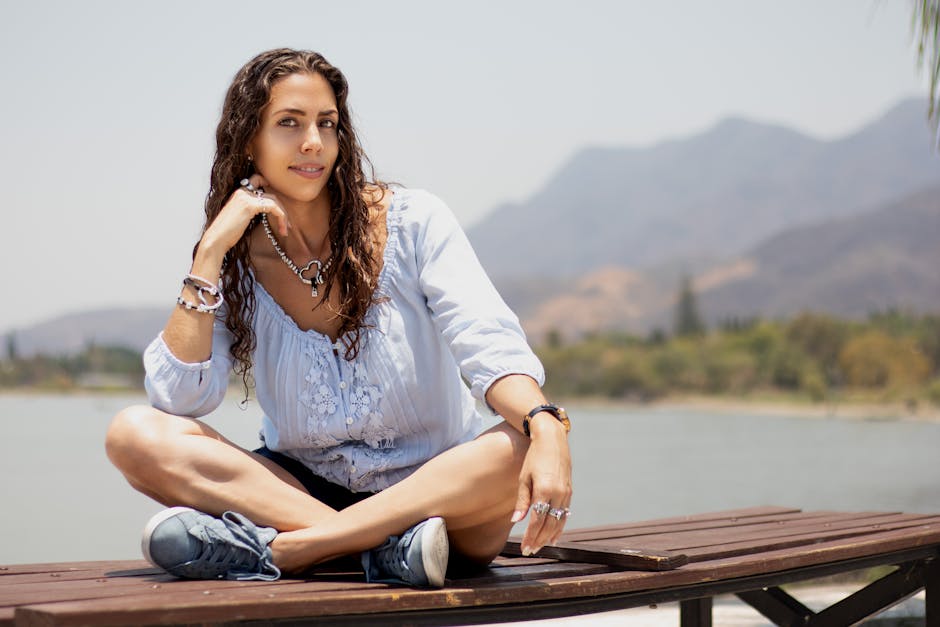 Woman in a peaceful yoga pose on a wooden pier by the lake at dawn.